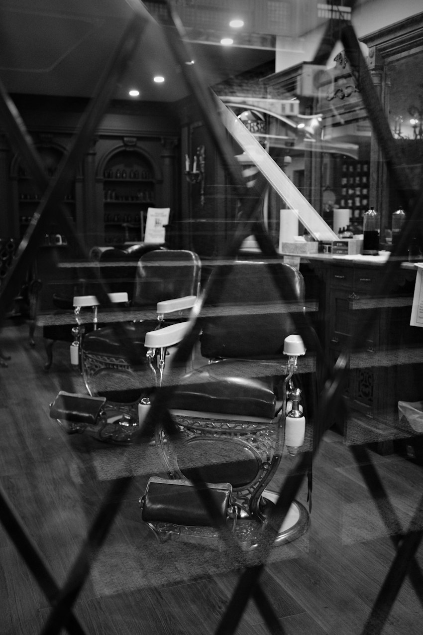 Classic barber chairs reflected in a shop window